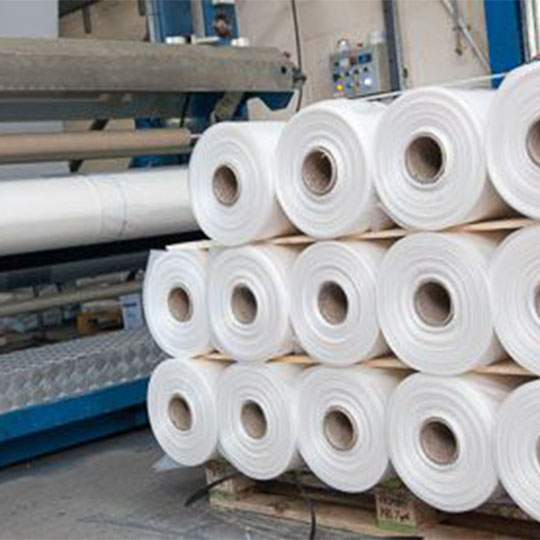 14 rolls stacked up on top of each waiting to be processed, with one already on the machine.